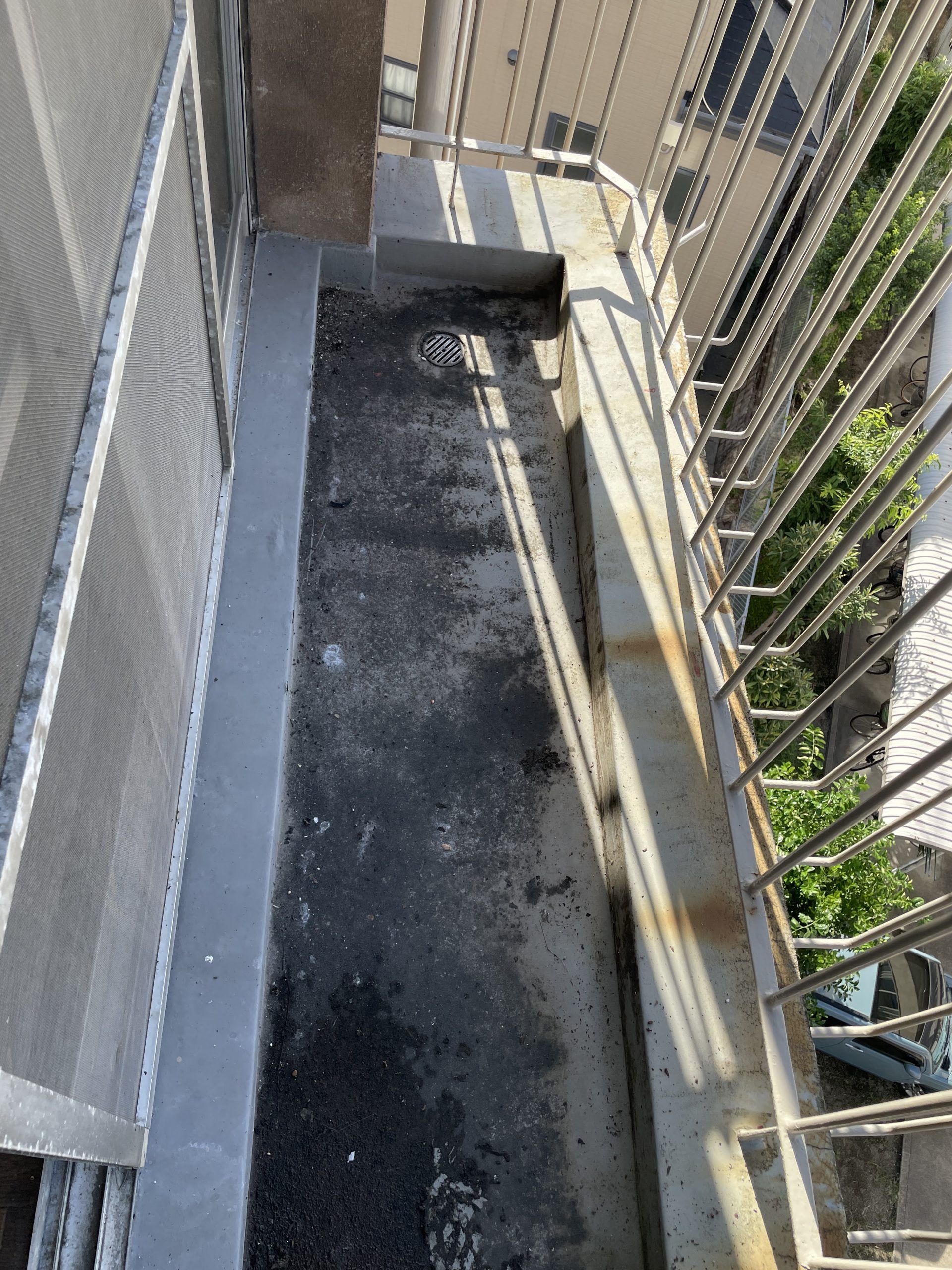 ベランダ床には黒ずみや汚れが広がり、防水層の経年劣化が確認されました。