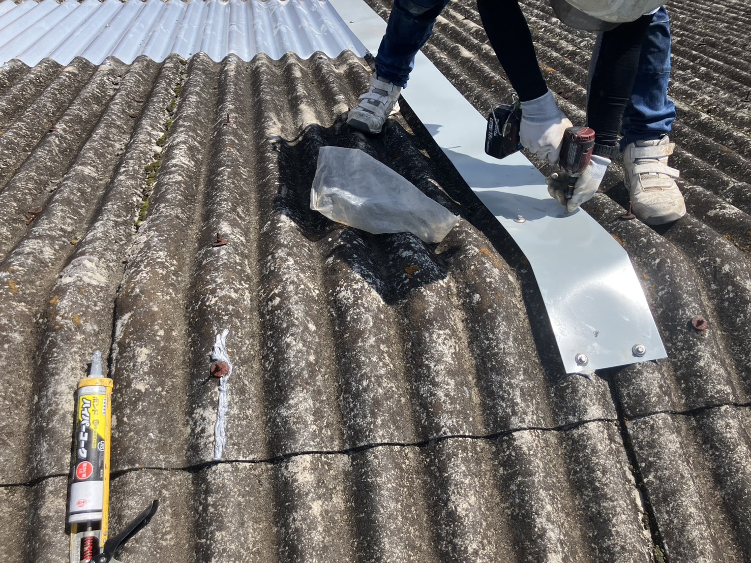 押さえ板金を取り付け、採光板の破損箇所をガルバリウム鋼板で補修しました。